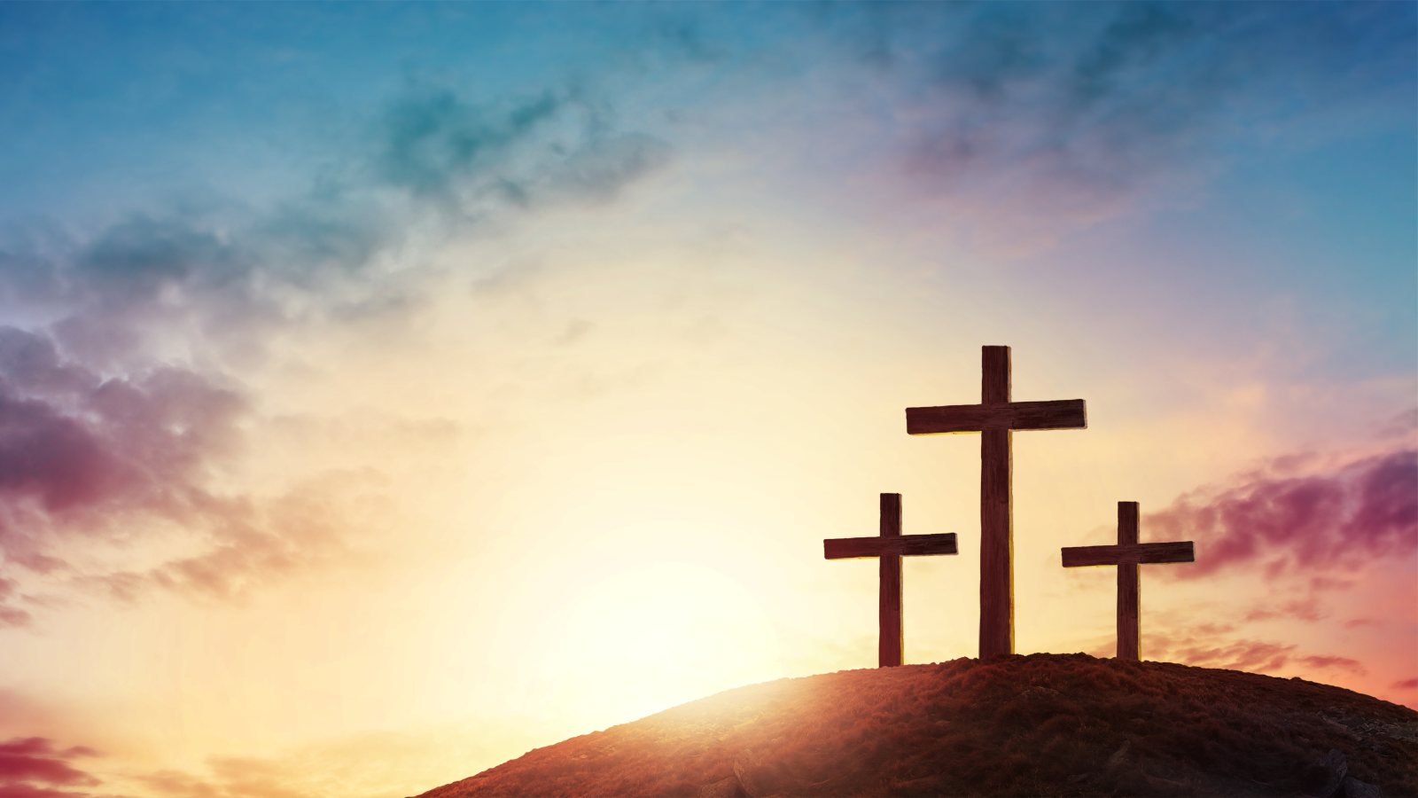 Silhouette cross on Calvary mountain sunset background. Easter concept; cross Christian
